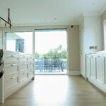 White/gold kitchen open plan into outdoor space