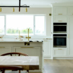 Living space into kitchen with oven gold tap and gold lighting